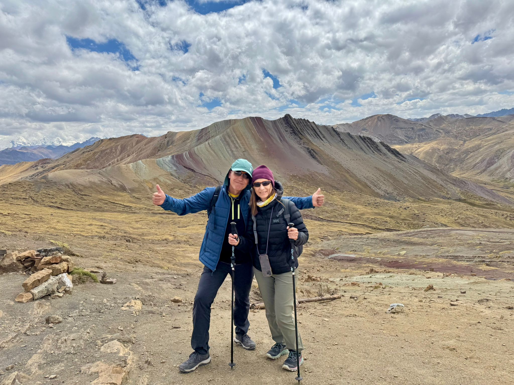 Clientes de Kareba Viatges especializas en viajes alternativos y de aventura posando para la foto frente a la Montaña de 7 Colores en Perú.