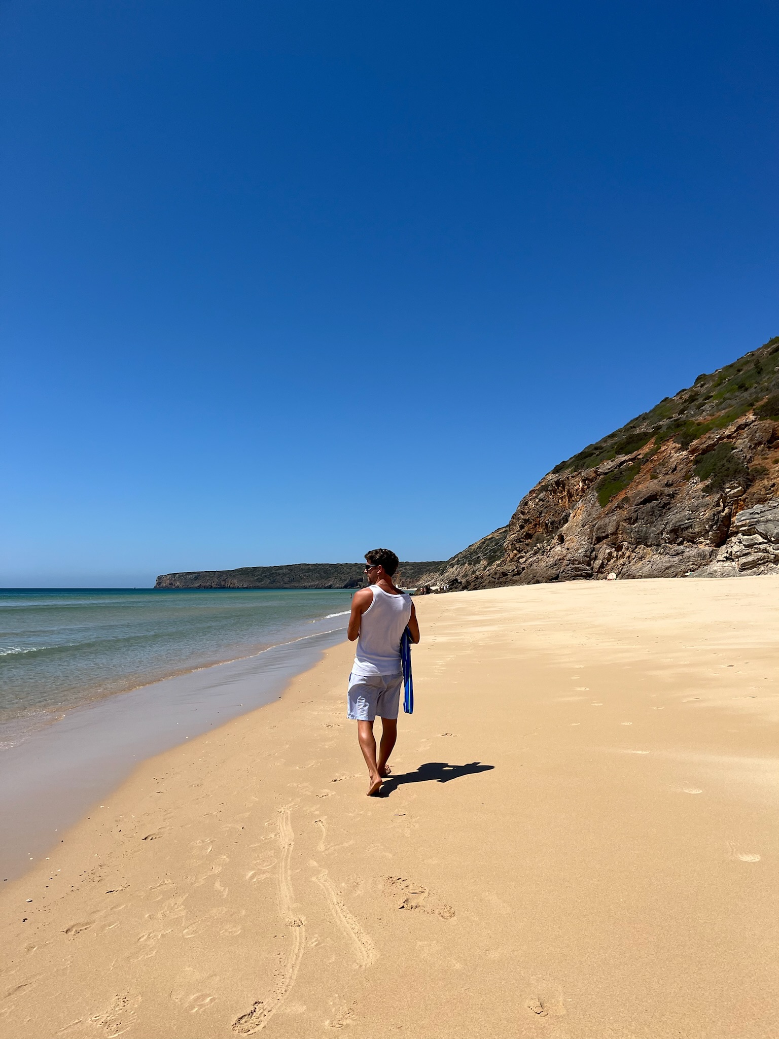playa salvaje del algarve con viajero caminando