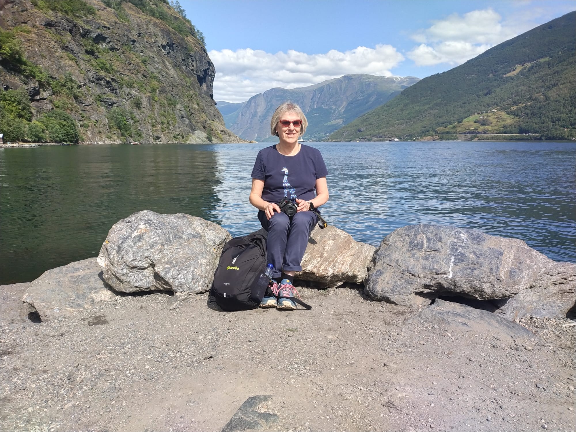 viajera descansando frente a un fiordo en noruega