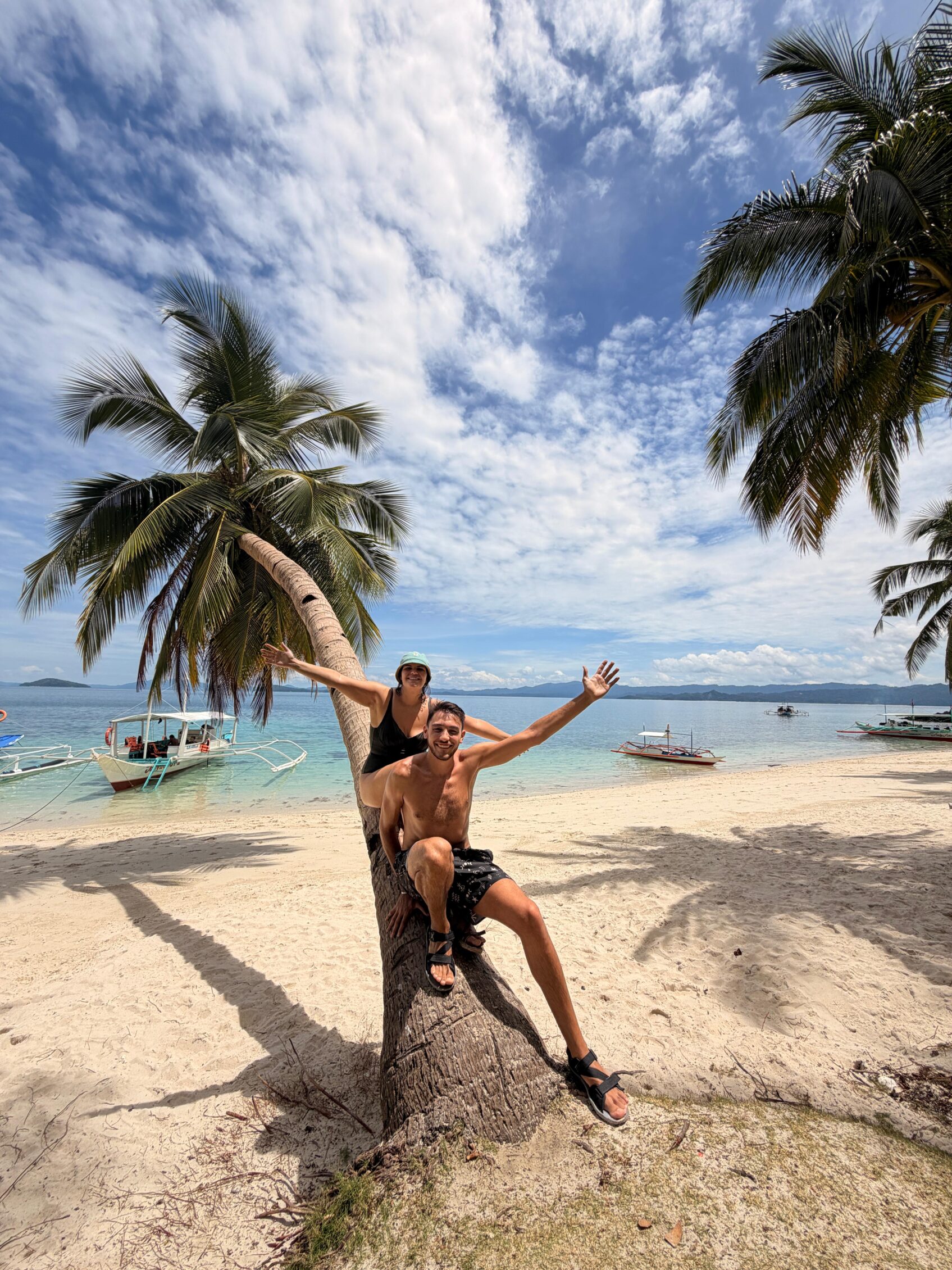 viajeros encima de una palmera en una playa en filipinas